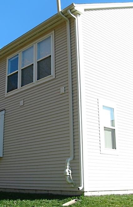 Radon mitigation pipe running up the side of a house